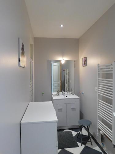 une salle de bain blanche avec un lavabo et un miroir dans l'établissement La Petite Barrière, à Ozillac