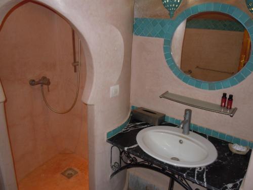 a bathroom with a sink and a mirror at Kasbah Hotel Ait Omar in Nkob