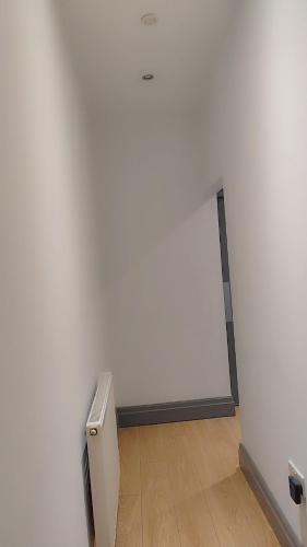 an empty room with a white wall and a wooden floor at Double-Bedroom in the Heart of Eccles Manchester BH4 Perfect for Short Stays in Manchester