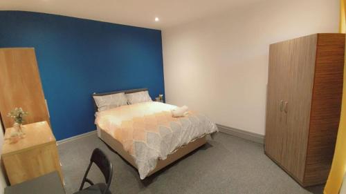 a bedroom with a bed and a blue wall at Double-Bedroom in the Heart of Eccles Manchester BH4 Perfect for Short Stays in Manchester