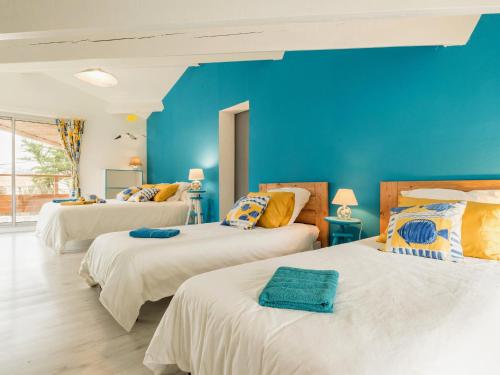 - 3 lits dans une chambre aux murs bleus dans l'établissement Grande maison lumineuse, jardin clos, Wi-Fi inclus - FR-1-306-1295, à Pornic