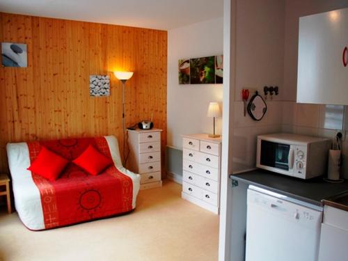 - une petite chambre avec un lit et un four micro-ondes dans l'établissement Charmant studio au cœur de la station - FR-1-814-15, à Besse-et-Saint-Anastaise