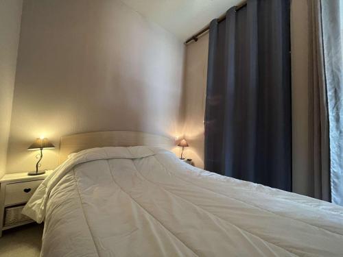 une chambre avec un lit et un rideau bleu dans l'établissement Appt Studio cabine LA ROCHELLE - LR040-003, à La Rochelle