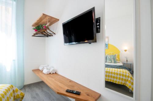 a room with a tv on the wall and a bed at aMoneglia, 2 minutes walk to the beach, PVT PARK in Moneglia