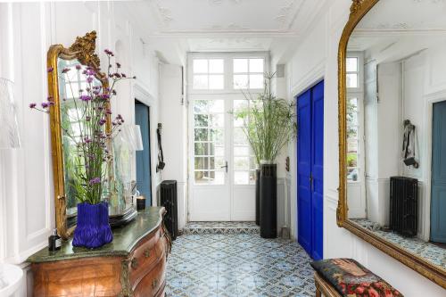a hallway with a mirror and a dresser with flowers on it at Malouinière Guillaume Onffroy in Saint Malo
