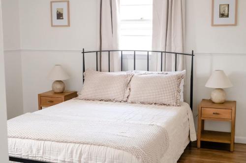 ein Schlafzimmer mit einem Bett mit zwei Nachttischen und zwei Lampen in der Unterkunft Wooded Cottage in Elizabethtown with hot tub and sauna in Elizabethtown