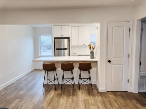 a kitchen with a counter and three stools in it at Downtown OS 2bed 1 bath with pool and close to the beach in Ocean Springs