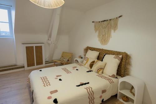 - une chambre avec un grand lit et un couvre-lit blanc dans l'établissement Appartement Cosy, à Oloron-Sainte-Marie