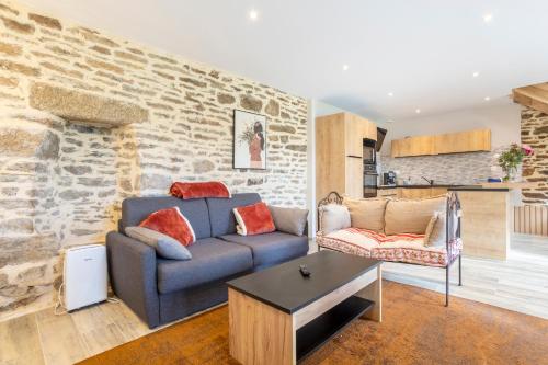 un salon avec un canapé bleu et une table dans l'établissement Le Penty - proche plages et centre, à Concarneau