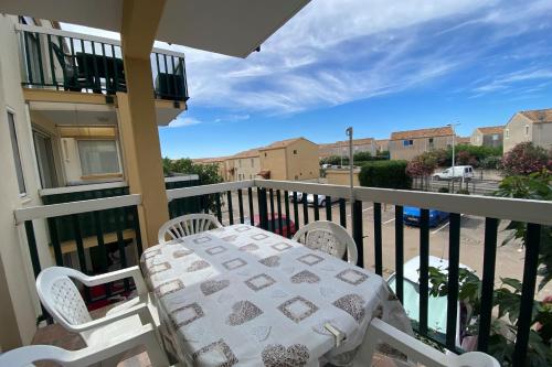 un porche avec une table et des chaises sur un balcon dans l'établissement The echo of the waves, à Frontignan