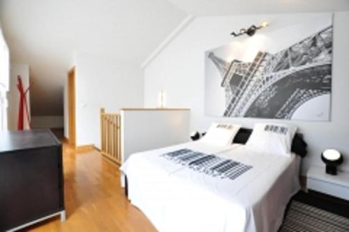 オリオにあるOrio Apartmentsの白いベッドと壁に絵画が飾られたベッドルーム1室