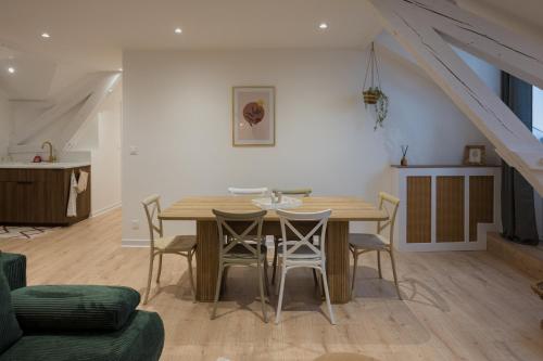 une salle à manger avec une table et des chaises en bois dans l'établissement Appartement Cosy, à Oloron-Sainte-Marie