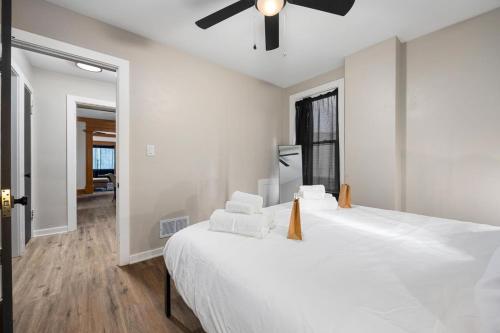 een slaapkamer met een wit bed met een plafondventilator bij Peaceful 2BD - Perfect for Long-term stays in Peoria