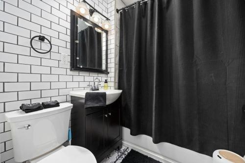 een badkamer met een zwart douchegordijn en een toilet bij Peaceful 2BD - Perfect for Long-term stays in Peoria