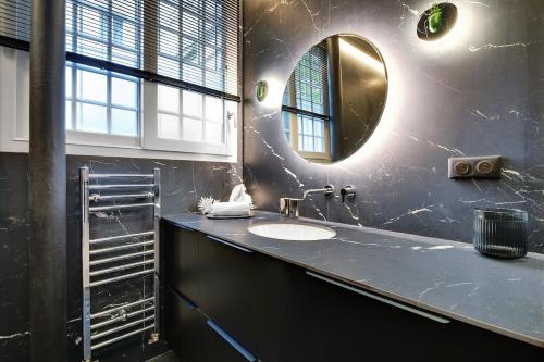 une salle de bain avec un lavabo et un miroir dans l'établissement Le Marais Luxury & Trendy Apartment, à Paris