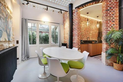 une salle à manger avec une table et des chaises blanches dans l'établissement Le Marais Luxury & Trendy Apartment, à Paris