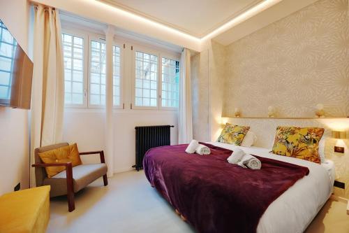 une chambre avec un grand lit et une chaise dans l'établissement Le Marais Luxury & Trendy Apartment, à Paris