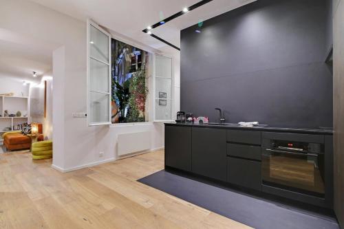 une cuisine avec un comptoir noir et une fenêtre dans l'établissement Saint Andre Des Arts HEART of PARIS Design, à Paris