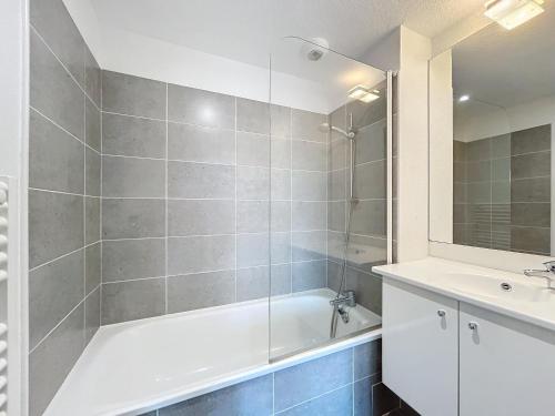 La salle de bains est pourvue d'une baignoire blanche et d'un lavabo. dans l'établissement 3303-Maison 6 couchages avec piscine, à Argelès-sur-Mer