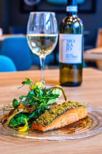 a plate of food with a glass of wine and a bottle at Hilton Garden Inn Abingdon Oxford in Abingdon