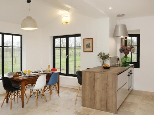 une cuisine et une salle à manger avec une table et des chaises en bois dans l'établissement La Maison Aux Fleurs by La Boîte En Plus, à Courteuil