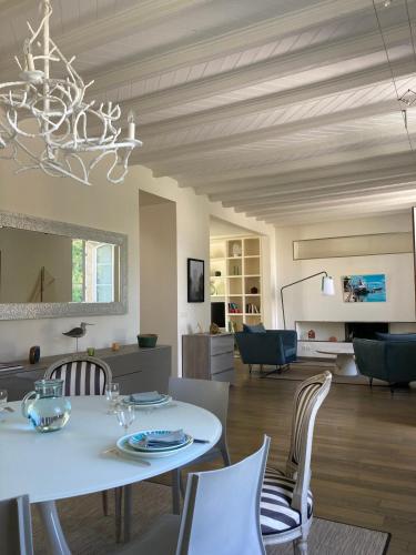 une salle à manger avec une table et des chaises blanches dans l'établissement Une pause sous les palmiers - île aux moines, à l'Île-aux-Moines