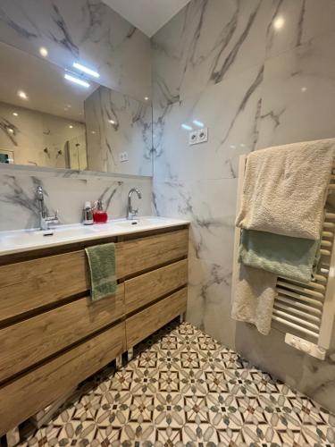 łazienka z umywalką i dużym lustrem w obiekcie Cosy flat next Casino in Monaco w mieście Beausoleil