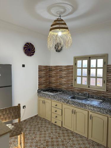 a kitchen with a sink and a chandelier at Villa Sakina home with private pool sidi kaouki in Essaouira