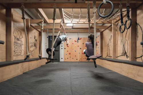 a group of people on a climbing wall in a gym at Haunold Homes in San Candido