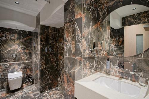 a bathroom with a tub and a toilet and a mirror at Golden Plaza in Ahmedabad