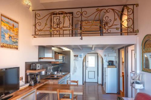 Il comprend une grande cuisine dotée de parquet et d'un balcon. dans l'établissement Maison sur la roche, terrasse avec sublime vue mer, classée 5 étoiles, quartier des peintres, au calme, parking privé, clim et wifi, à Collioure