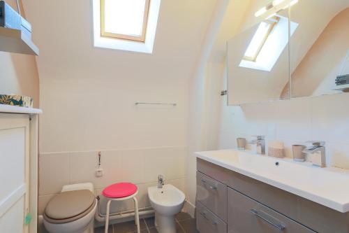 a bathroom with a toilet and a sink and a mirror at Maison du pêcheur 150 m plages in Saint-Quay-Portrieux