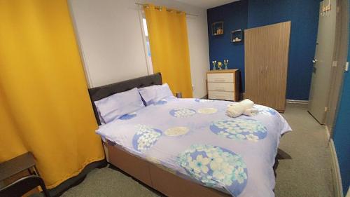 a bedroom with a bed with blue and yellow walls at En-suite Double-Bedroom in the Heart of Eccles Manchester BH5 Perfect for Short Stays in Manchester