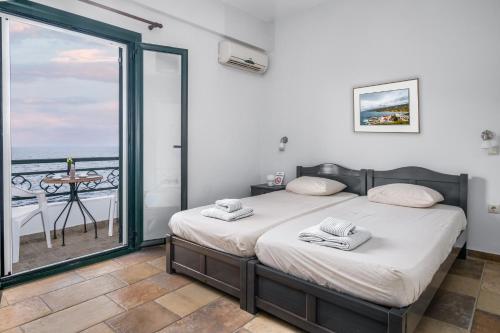 a bedroom with two beds and a view of the ocean at Casa del Sol in Kouniádhoi