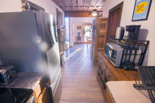a kitchen with a stainless steel refrigerator and wooden floors at Rustic Retreat Fireplace, Casino, Camelback Close to everything! in Mount Pocono