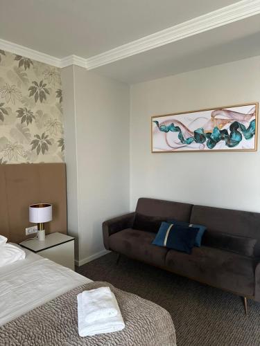 a bedroom with a couch and a bed in it at Hotel Forras in Komárom