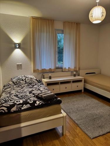 Un dormitorio con una cama y un escritorio y una ventana. en Ferienhaus Willenborg, en Molbergen