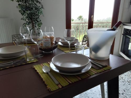 a table with plates and wine glasses on it at Casa Olivella in Bardolino