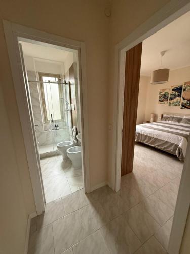 a bedroom with a bed and a bathroom with a toilet at Casa ViVa Cernusco - Bilocale in Cernusco sul Naviglio