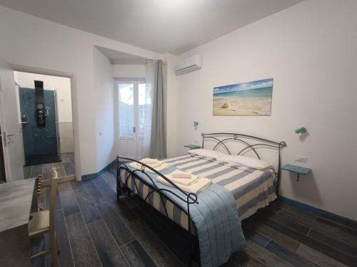 a bedroom with a bed and a table and a window at Porto Sicuro Hospitality in Cagliari