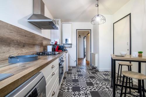 - une cuisine avec des placards blancs et du carrelage noir et blanc dans l'établissement Jungle Indus - Centre & gare à pied, à Vannes