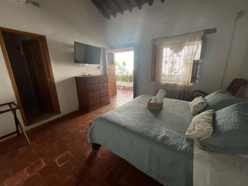 a bedroom with a bed and a dresser and a television at Hotel Archangelus in Mompós