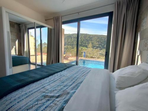 a bedroom with a bed and a view of a pool at Casa-Bananeira-Villa-4P-en-baby-with-private-pool-in-a-natural-setting in São Bartolomeu de Messines