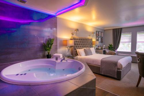 a large bathroom with a tub and a bed at Moor Hall Hotel & Spa in Sutton Coldfield