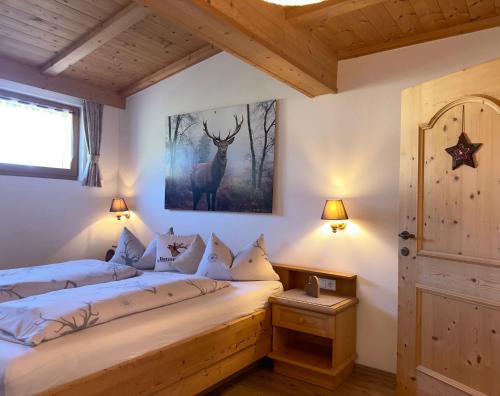 a bedroom with a bed with a deer picture on the wall at Untertalhof in Castelrotto