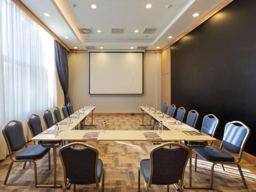 a conference room with tables and chairs and a whiteboard at Park Inn by Radisson Samsun in Samsun