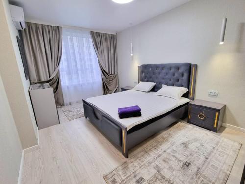 - une chambre avec un lit doté d'un oreiller violet dans l'établissement Бизнес Класс ALA PARK!, à Almaty