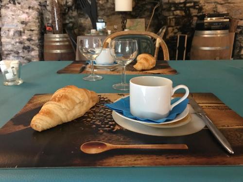 Ein Tisch mit einer Kaffeetasse, Croissants und Gläsern in der Unterkunft Domaine d'Alcapiès in Saint-Jean-dʼAlcapiès