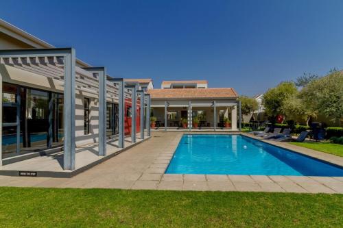 una piscina frente a una casa en Tranquil Urban Oasis with FREE Gym and Pool, en Sandton