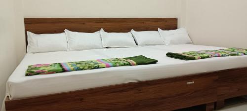 乌贾因Maa Shakambhari Homestay的一张铺着白色床单和枕头的大床